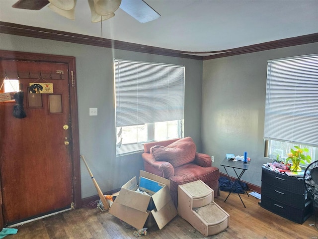 living area with crown molding and wood-type flooring