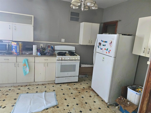 kitchen with white cabinetry, a notable chandelier, and white appliances