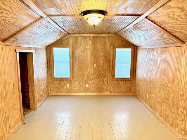 bonus room with wood ceiling, wooden walls, and light wood-type flooring