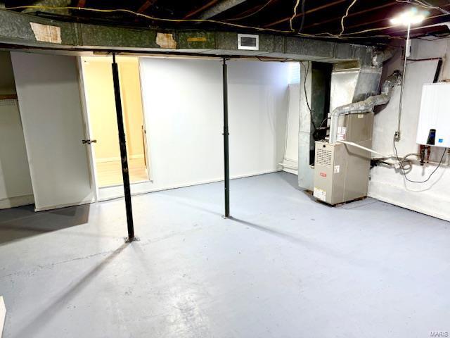 basement featuring heating unit and water heater