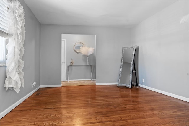 unfurnished room with wood finished floors and baseboards