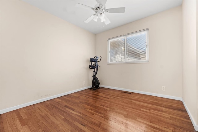 unfurnished room with ceiling fan, wood finished floors, visible vents, and baseboards