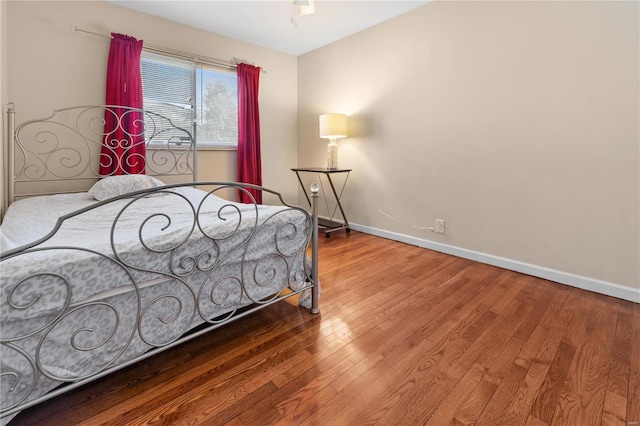 bedroom featuring baseboards and wood finished floors