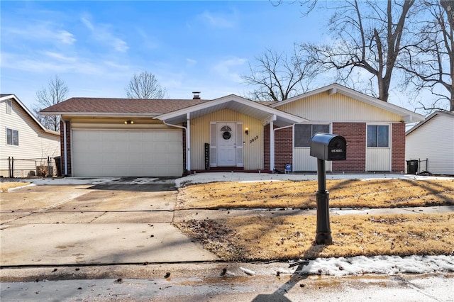 single story home with brick siding, driveway, and an attached garage