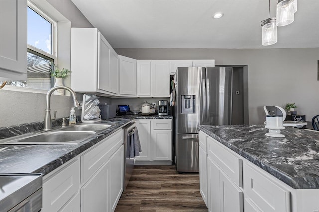 kitchen featuring pendant lighting, sink, appliances with stainless steel finishes, white cabinets, and dark hardwood / wood-style flooring