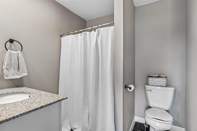 bathroom featuring vanity, curtained shower, and toilet