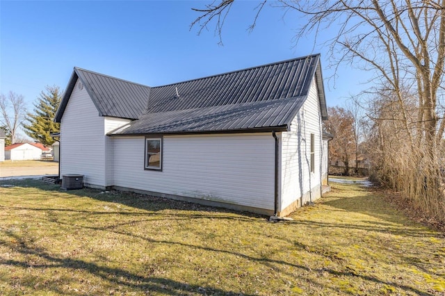 view of home's exterior with cooling unit and a yard