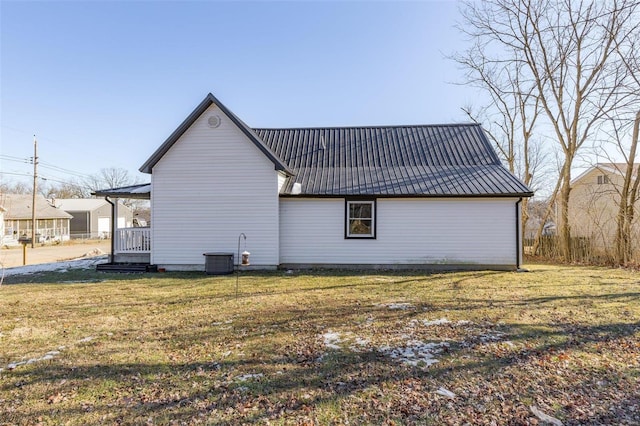 view of side of property with central AC unit and a yard