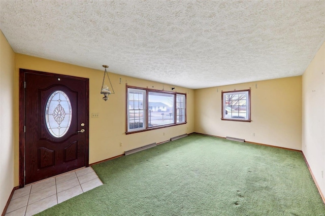 carpeted entrance foyer featuring baseboard heating and a textured ceiling