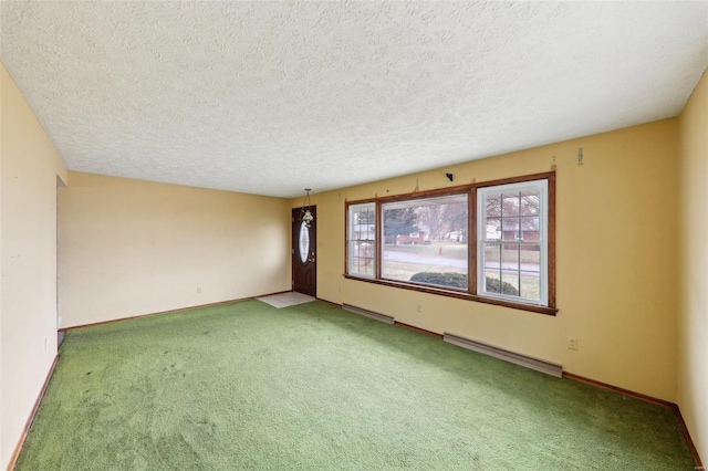 carpeted spare room with a textured ceiling and baseboard heating