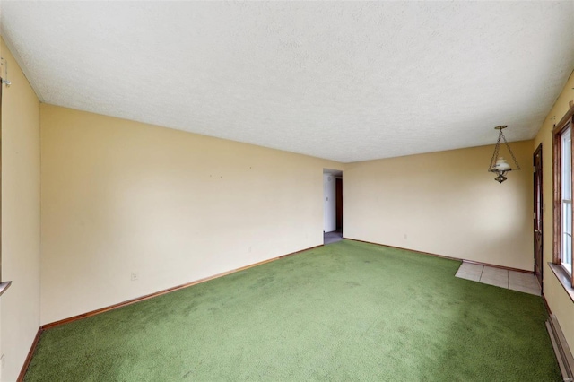 unfurnished room featuring dark colored carpet and a textured ceiling