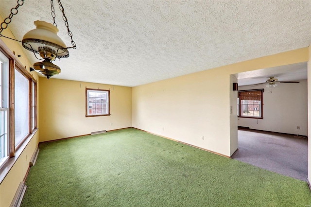 spare room with ceiling fan, carpet floors, a textured ceiling, and baseboard heating