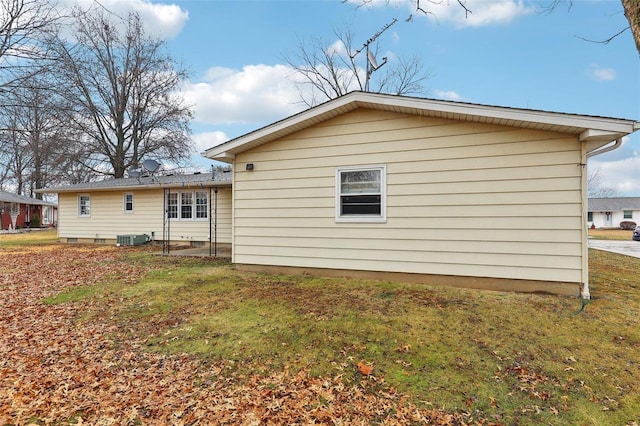 back of property with cooling unit and a lawn