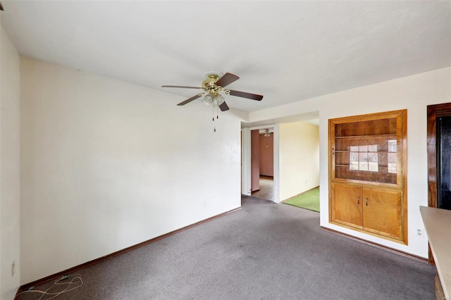 unfurnished room with dark carpet and ceiling fan