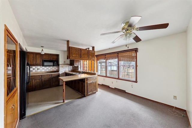 kitchen with sink, light carpet, dark brown cabinets, kitchen peninsula, and decorative backsplash