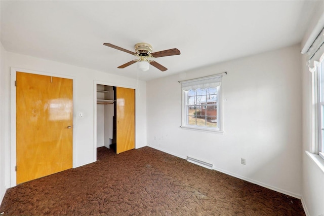 unfurnished bedroom with a closet, ceiling fan, and dark colored carpet