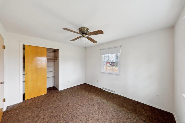 unfurnished bedroom featuring dark colored carpet, ceiling fan, and a closet