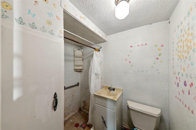 bathroom featuring vanity, a textured ceiling, and toilet