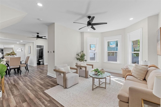 living room featuring wood-type flooring and ceiling fan