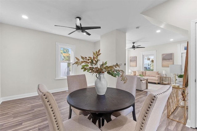 dining area featuring wood-type flooring and ceiling fan