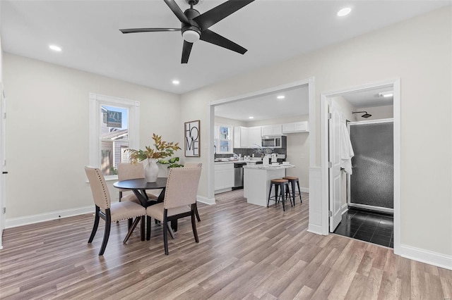 dining area with light hardwood / wood-style flooring and ceiling fan