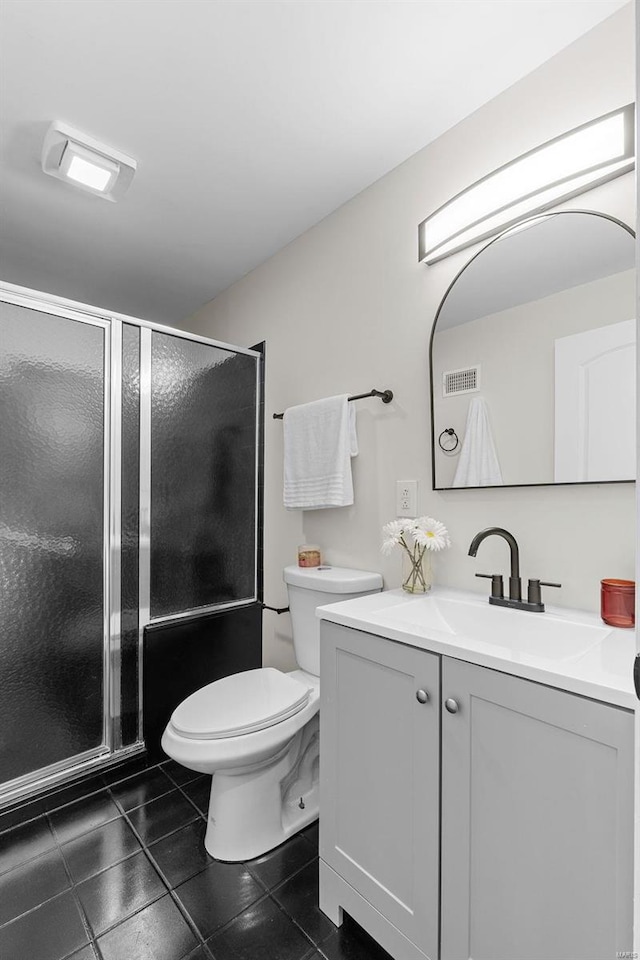 bathroom featuring tile patterned flooring, vanity, walk in shower, and toilet