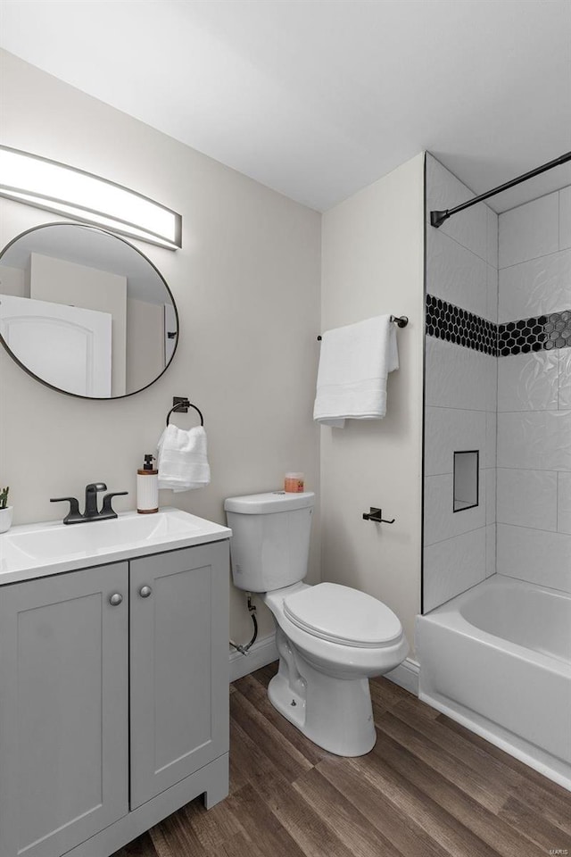 full bathroom featuring vanity, toilet, tiled shower / bath combo, and hardwood / wood-style floors