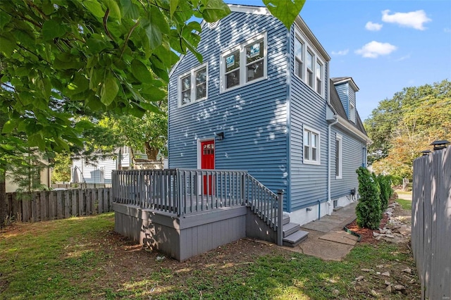 rear view of property featuring a wooden deck