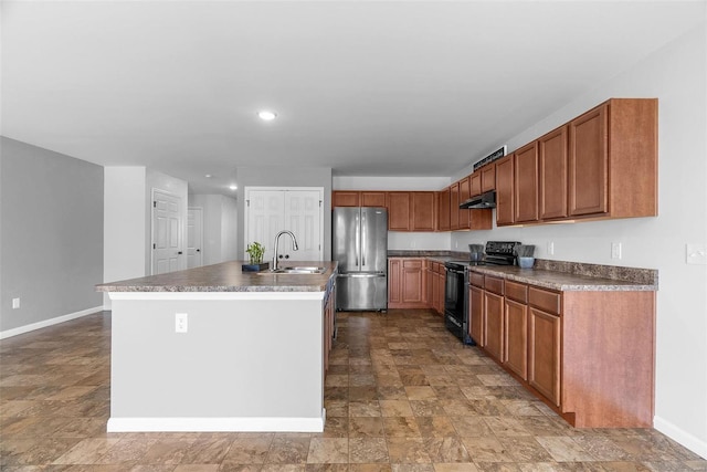 kitchen with sink, stainless steel fridge, black electric range, and a center island with sink