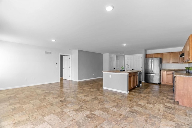 kitchen featuring appliances with stainless steel finishes, sink, ventilation hood, and a kitchen island with sink