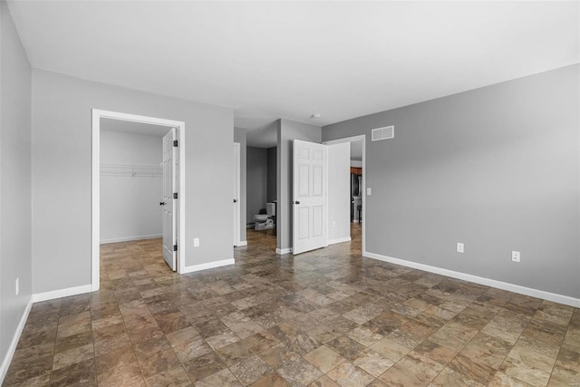 unfurnished bedroom featuring a walk in closet and a closet