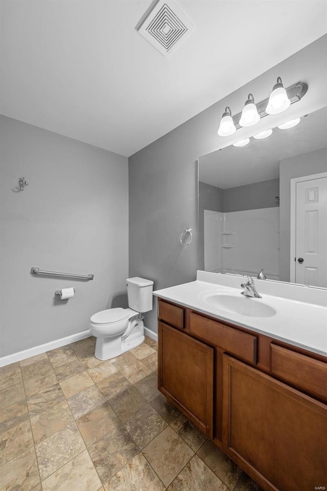 bathroom featuring vanity, a shower, and toilet