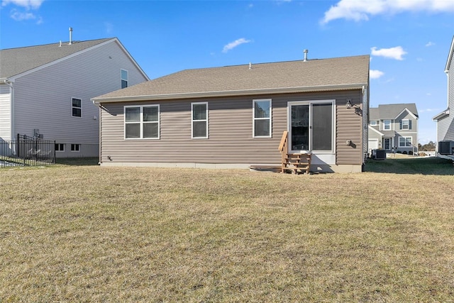 rear view of property featuring a yard and central AC