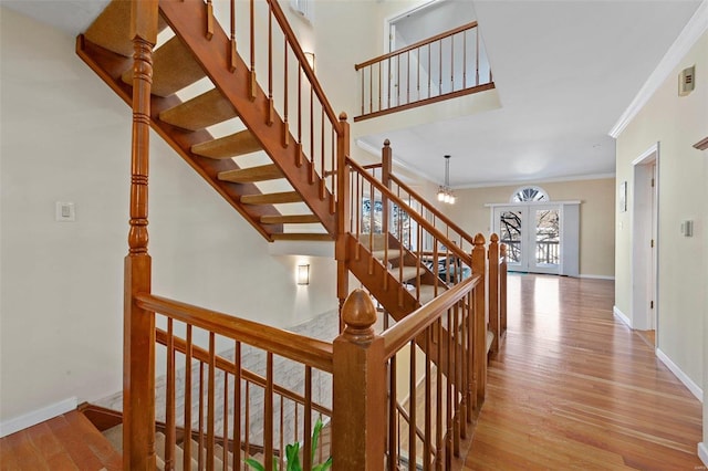 stairs with hardwood / wood-style floors and crown molding