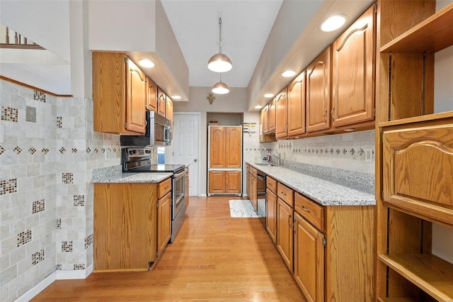 kitchen featuring sink, light stone counters, tasteful backsplash, pendant lighting, and stainless steel appliances