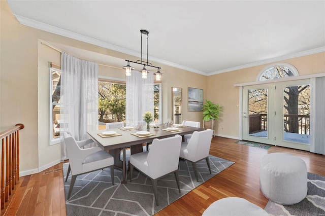 dining area featuring ornamental molding and dark hardwood / wood-style flooring