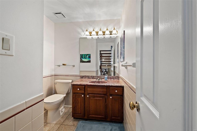 bathroom featuring vanity, tile walls, tile patterned floors, and toilet