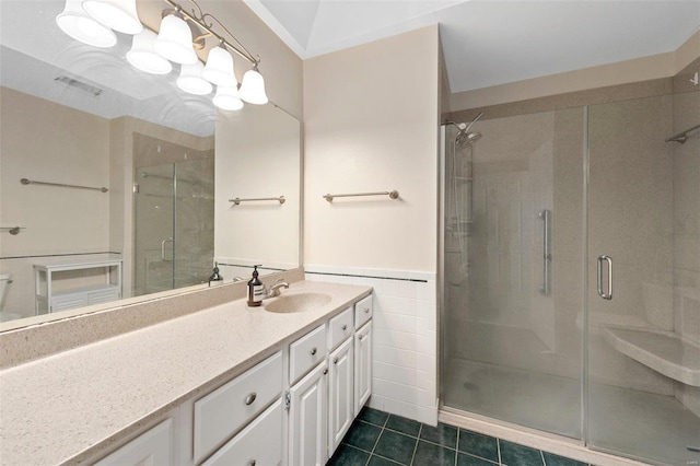 bathroom featuring tile walls, tile patterned flooring, vanity, a notable chandelier, and an enclosed shower