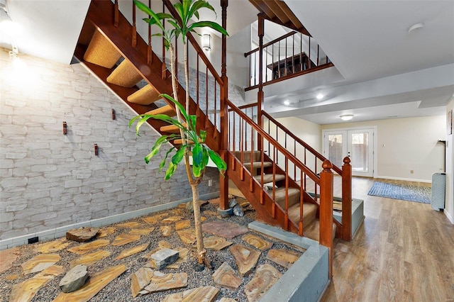 stairway featuring french doors and wood-type flooring