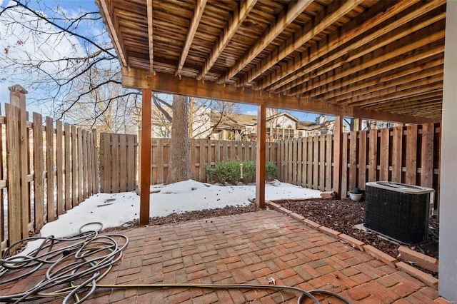 snow covered patio featuring cooling unit