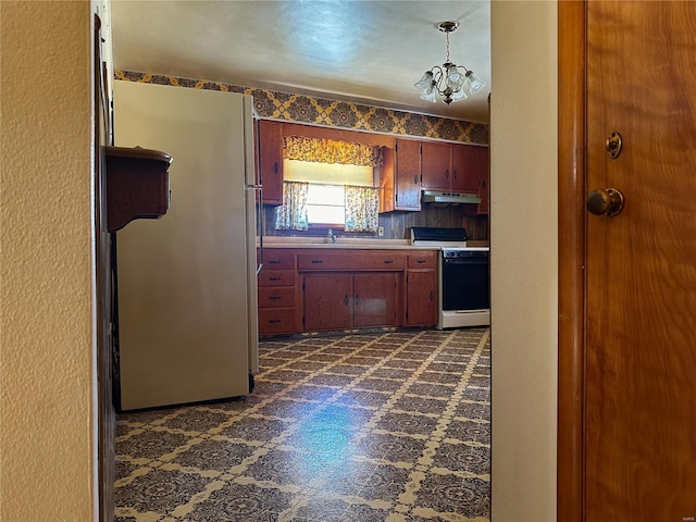 kitchen with sink, refrigerator, an inviting chandelier, hanging light fixtures, and range