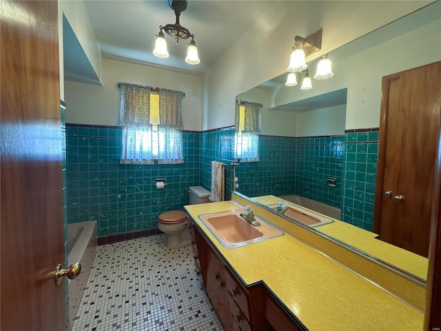 bathroom featuring tile patterned floors, toilet, tile walls, vanity, and a bath