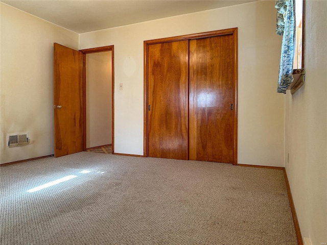 unfurnished bedroom with light carpet and a closet