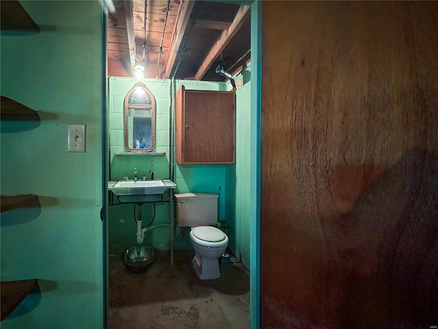 bathroom with toilet, vanity, and concrete flooring