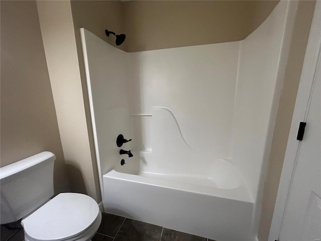 bathroom featuring washtub / shower combination, tile patterned floors, and toilet