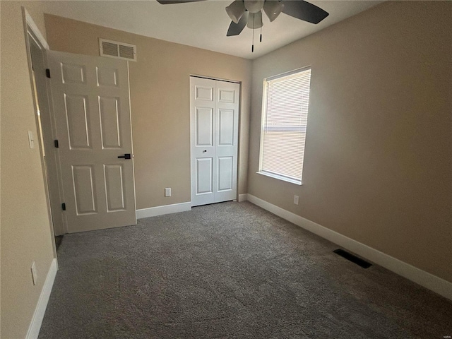 unfurnished bedroom featuring dark colored carpet, ceiling fan, and a closet