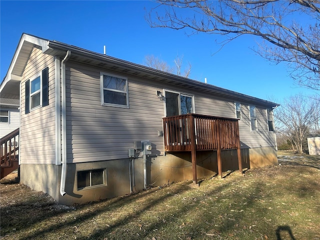 rear view of house with a yard and a deck