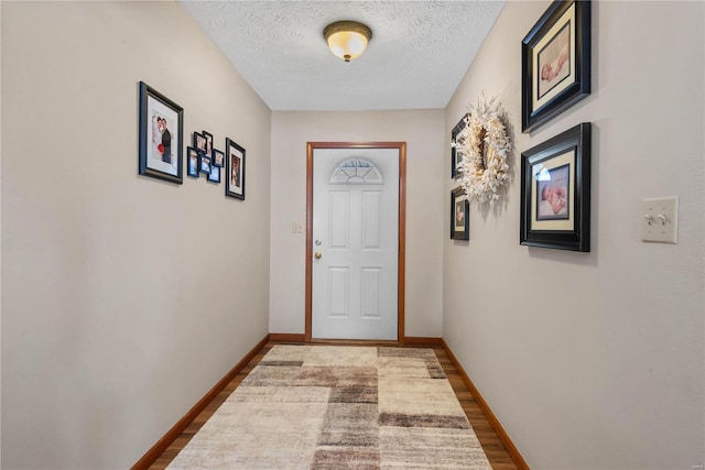 doorway with wood-type flooring and a textured ceiling