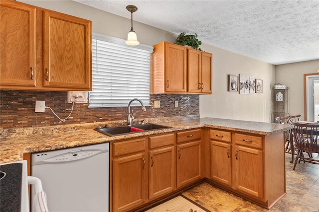 kitchen featuring sink, dishwasher, hanging light fixtures, a wealth of natural light, and kitchen peninsula