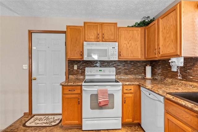 kitchen with a textured ceiling, light stone counters, backsplash, and white appliances